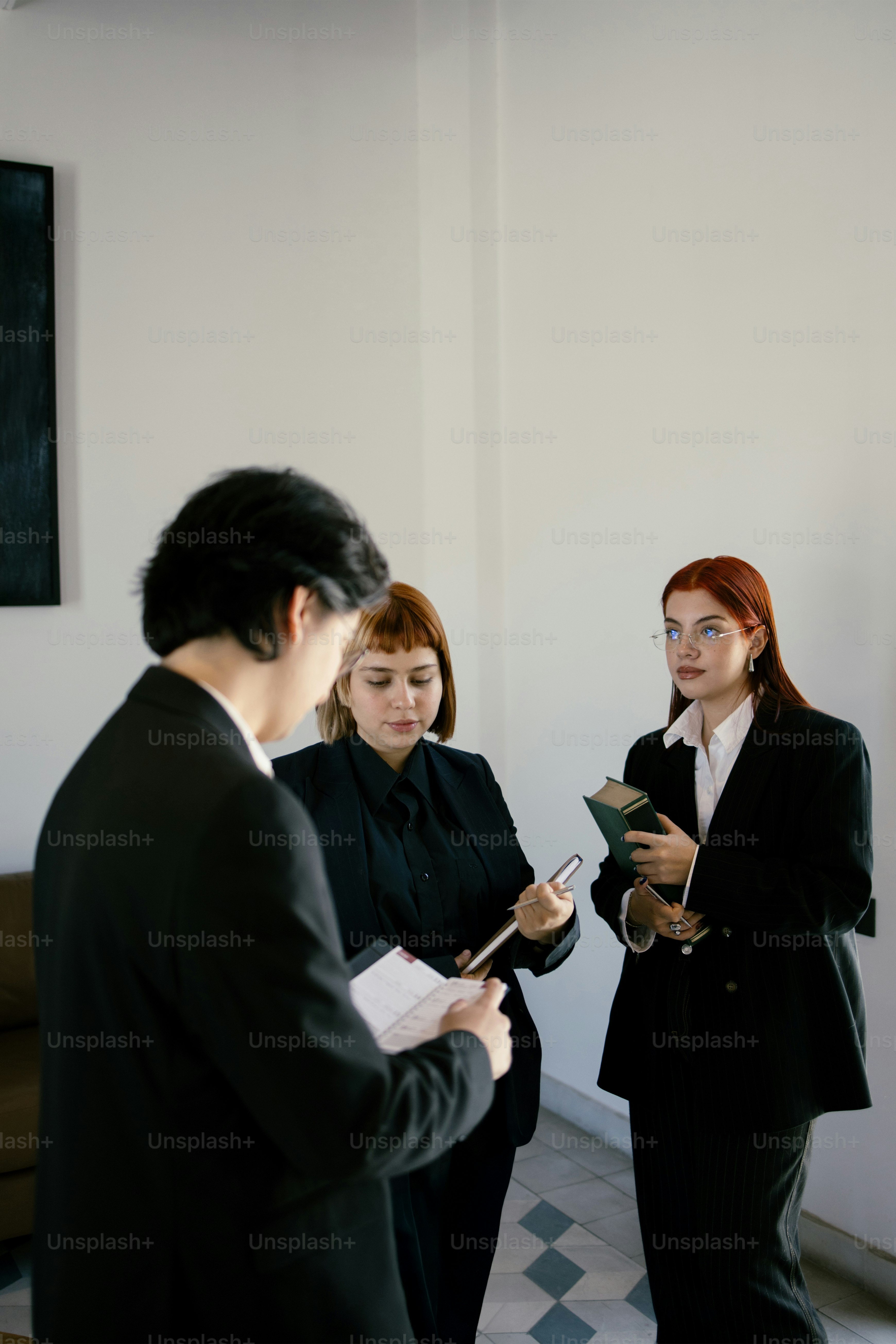 Three business people in suits are discussing.